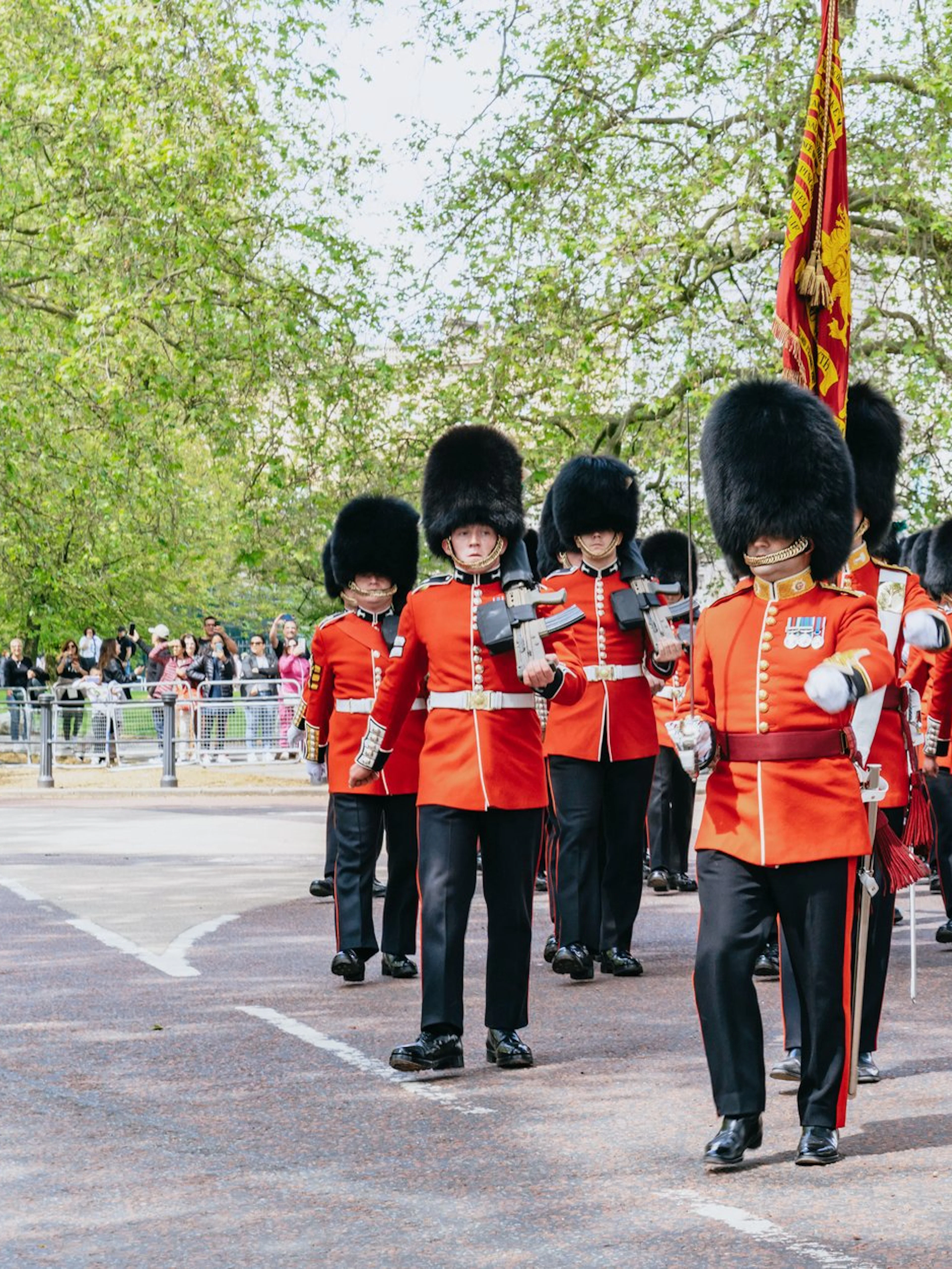 Guards in red uniforms marching during Changing of the Guard ceremony, London.