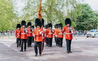 Guards in red uniforms marching during Changing of the Guard ceremony, London.