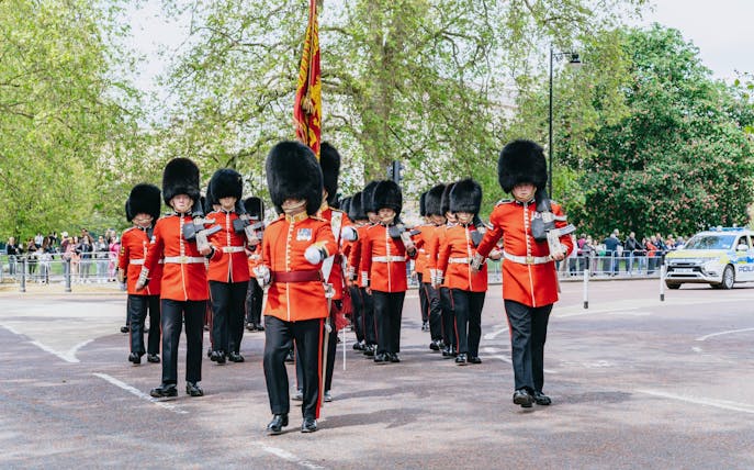 Guards in red uniforms marching during Changing of the Guard ceremony, London.
