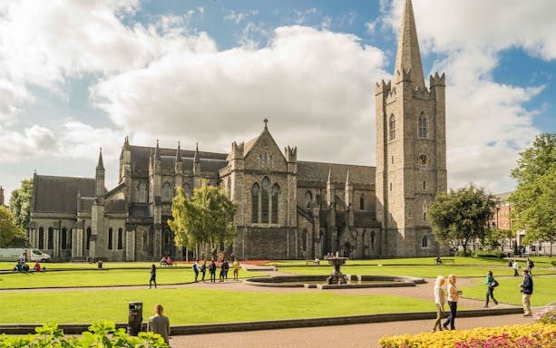St. Patrick's Cathedral in Dublin with visitors exploring the grounds.