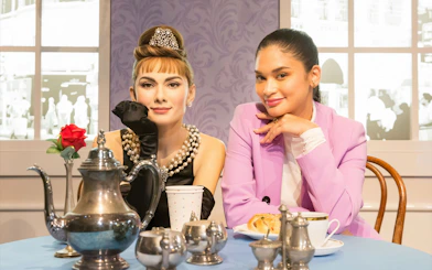 Wax figure at Madame Tussauds Hong Kong with a visitor at a tea table.