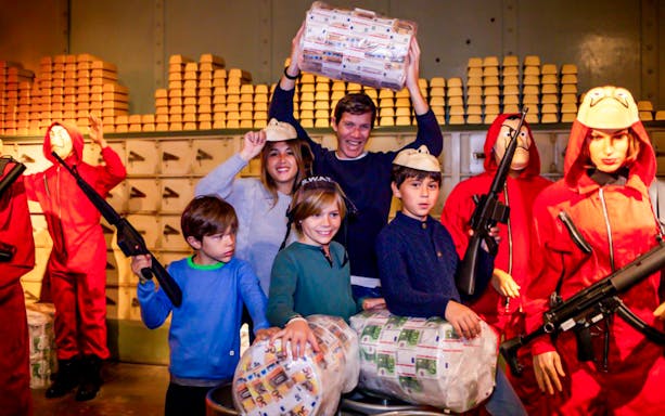 Visitors enjoying the Barcelona Wax Museum's heist-themed exhibit with costumed figures.
