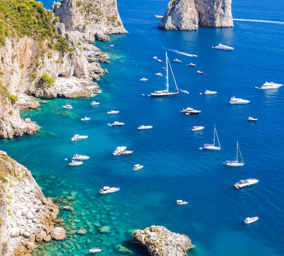Boats sailing near the Faraglioni rock formations on the Sorrento to Amalfi coast.