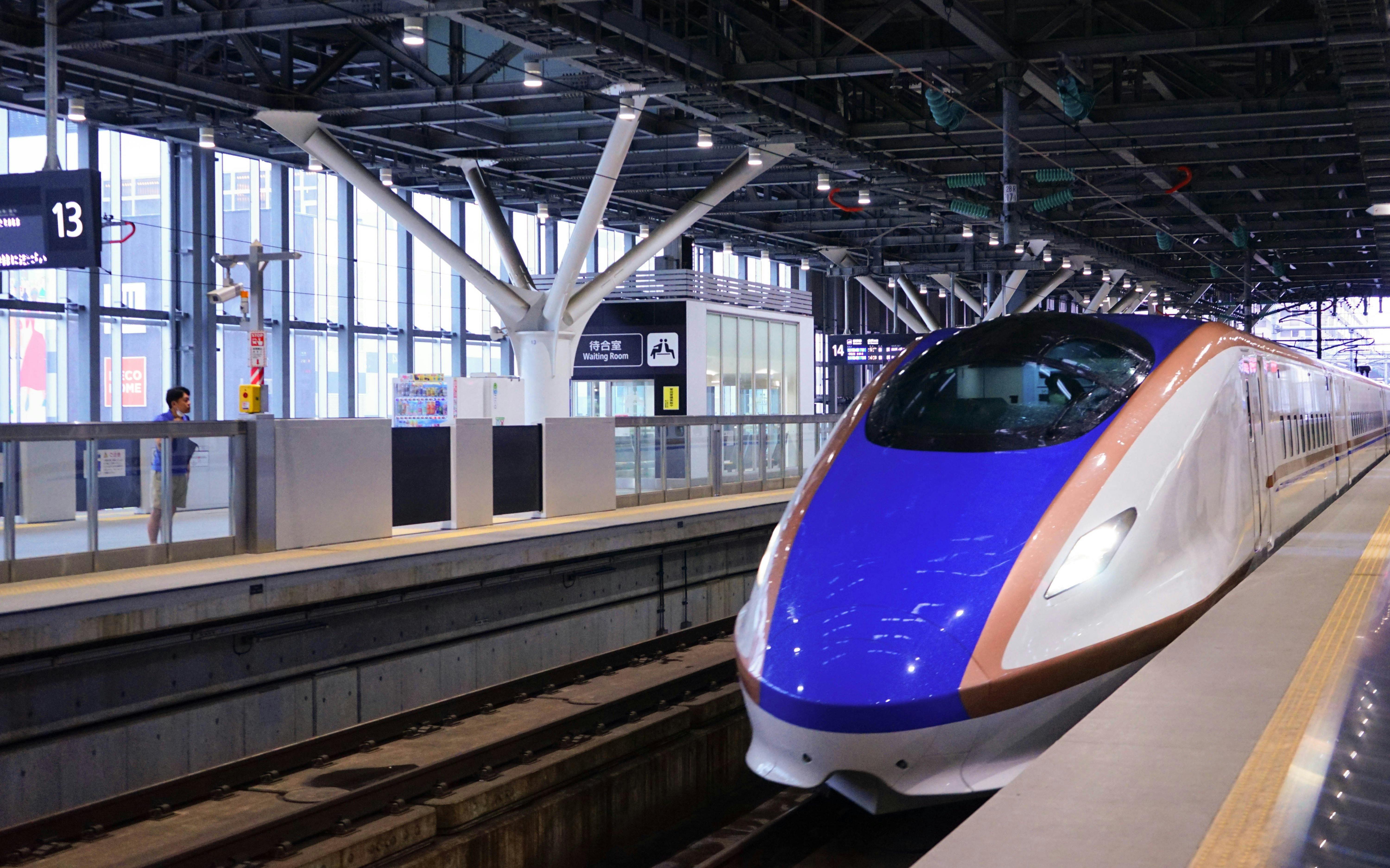 Hokuriku Shinkansen Hakutaka bullet train at a station platform in Japan.