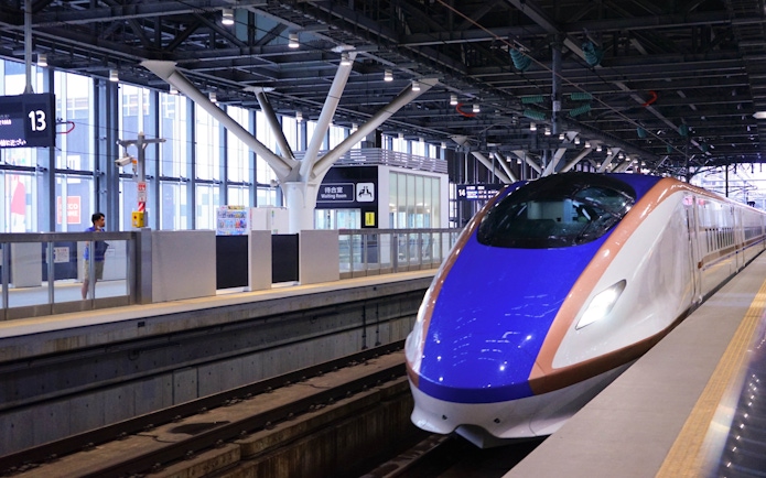 Hokuriku Shinkansen Hakutaka bullet train at a station platform in Japan.