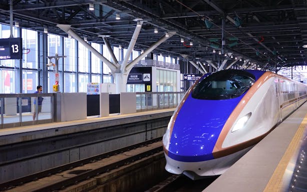 Hokuriku Shinkansen Hakutaka bullet train at a station platform in Japan.
