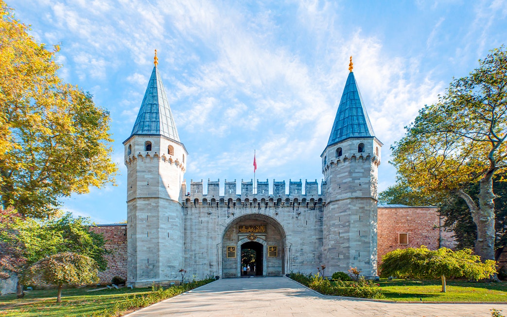 Topkapi Palace entrance with twin towers in Istanbul, Turkey, clear sky above.