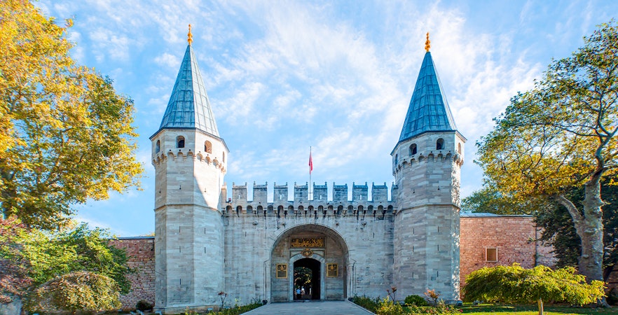 Topkapi Palace entrance with twin towers in Istanbul, Turkey, clear sky above.