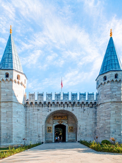 Topkapi Palace entrance with twin towers in Istanbul, Turkey, clear sky above.