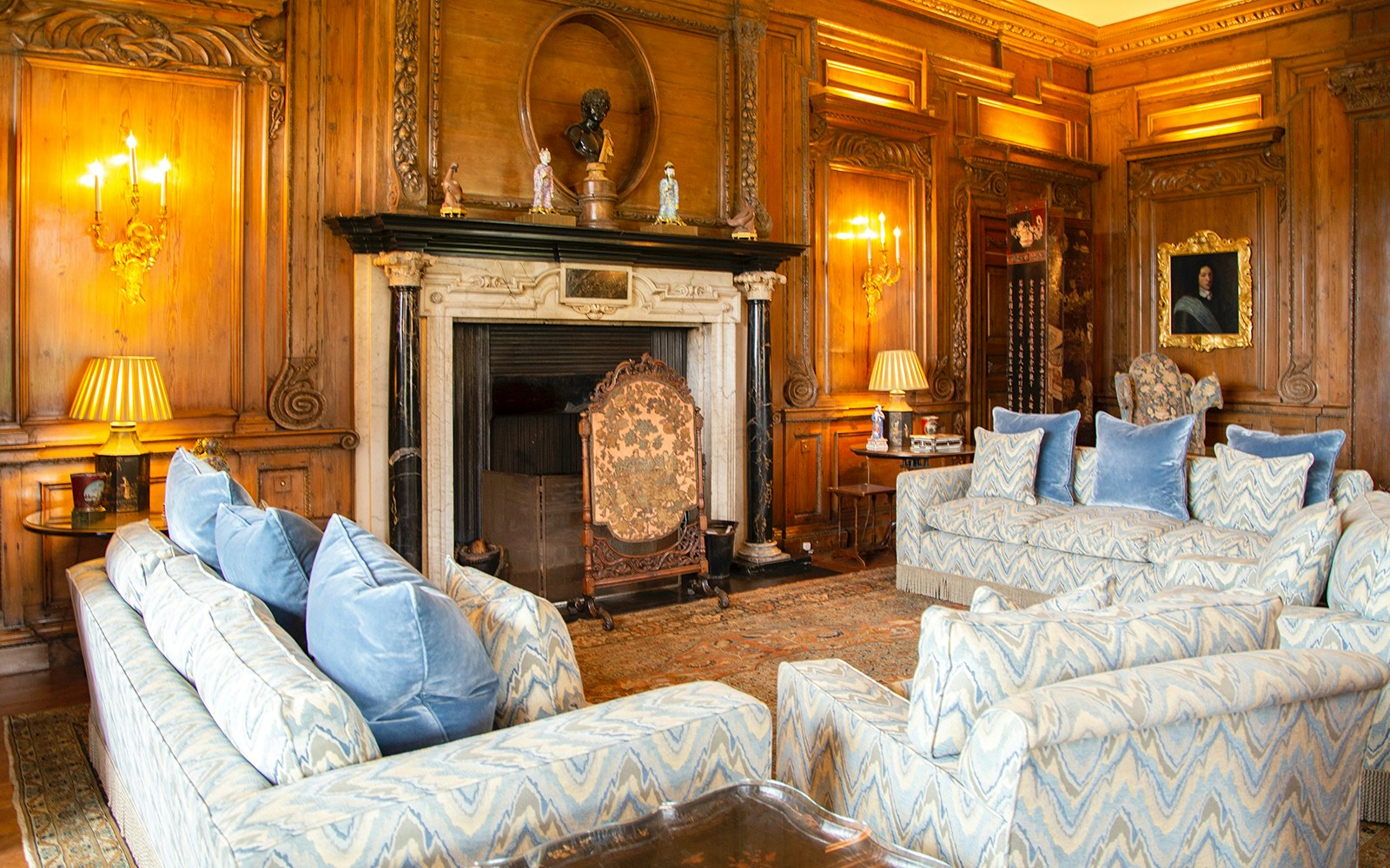 Leeds Castle interior with ornate fireplace and elegant seating area.