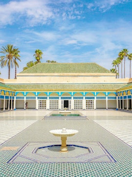 Bahia Palace courtyard with fountain and arched colonnade in Marrakech, Morocco.