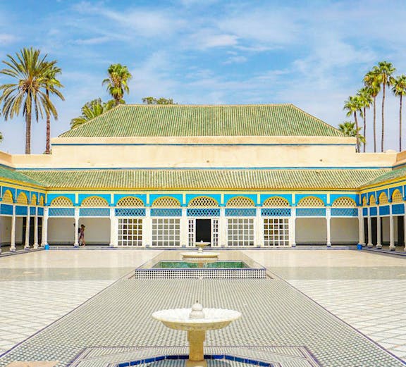 Bahia Palace courtyard with fountain and arched colonnade in Marrakech, Morocco.