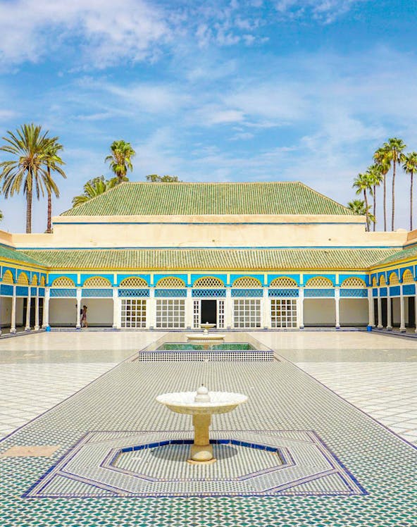 Bahia Palace courtyard with fountain and arched colonnade in Marrakech, Morocco.