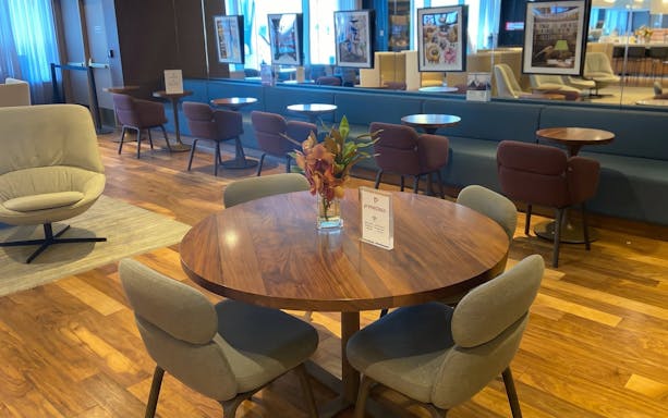 Primeclass Lounge seating area at JFK Airport, New York with tables and chairs.