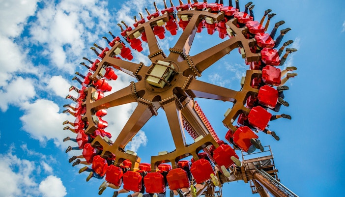 Aztec Swing ride at Energylandia amusement park, Poland, with riders in motion.