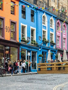 Colorful buildings and tourists on Victoria Street, Edinburgh, associated with Harry Potter.