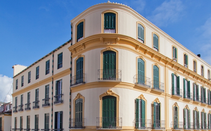 Facade of Picasso's Birthplace Museum in Málaga, Spain, with green shutters and balconies.