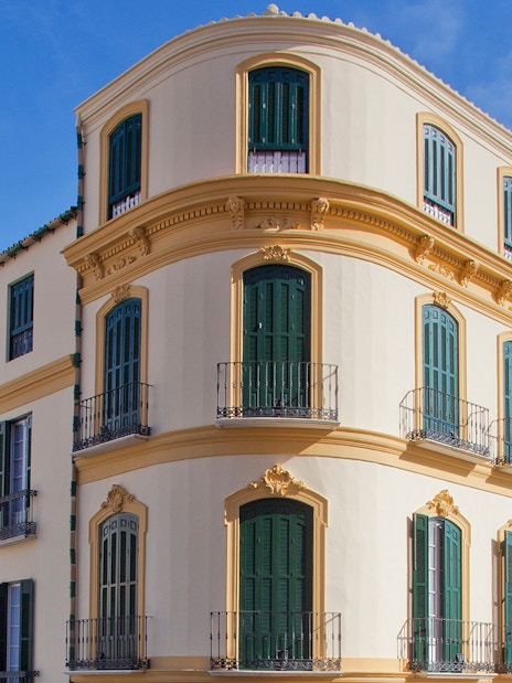 Facade of Picasso's Birthplace Museum in Málaga, Spain, with green shutters and balconies.
