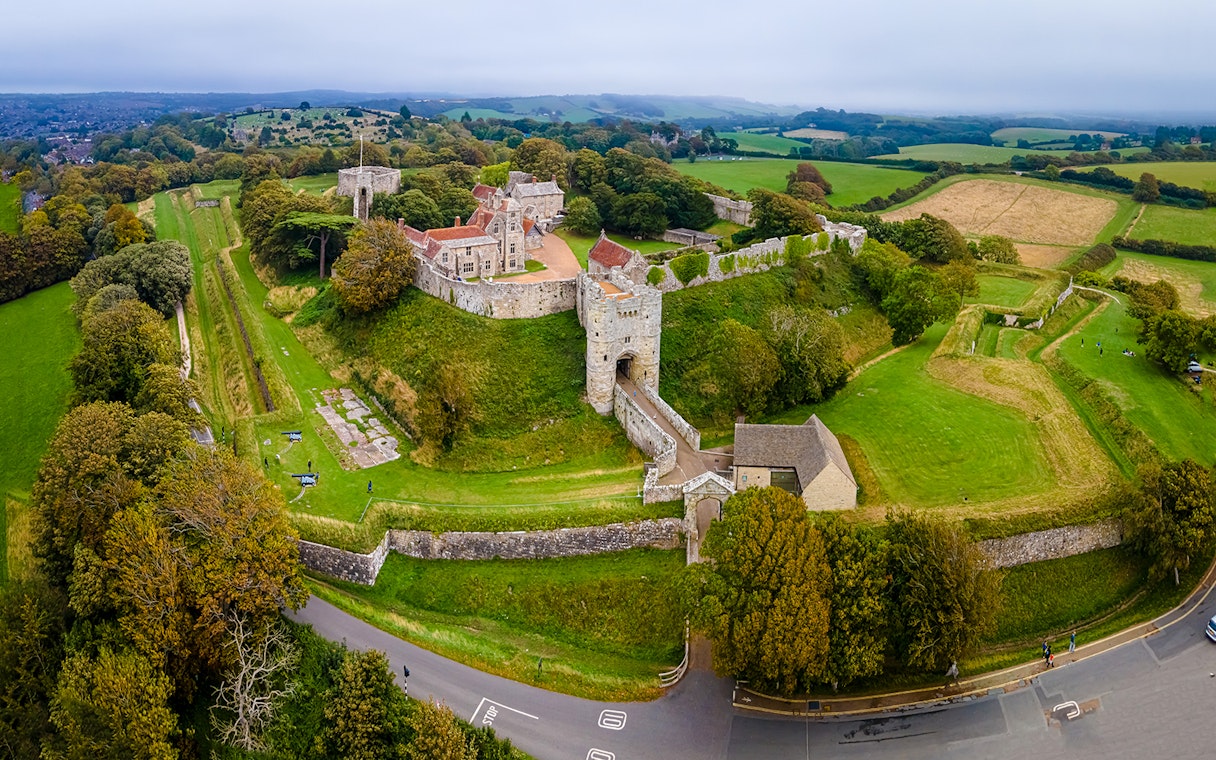 Aerial view of Carisbrooke Castle, Isle of Wight, surrounded by lush greenery and historic walls.
