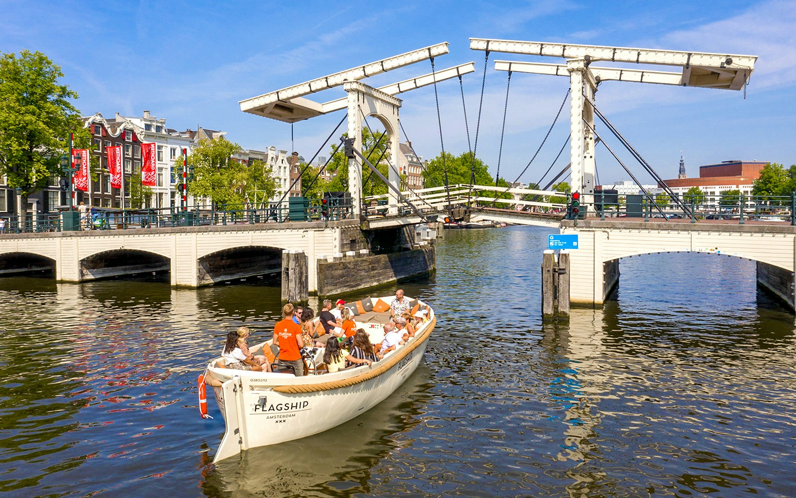 Boat tour crossing Skinny Bridge on Amsterdam's canal.