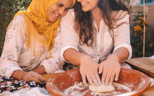 Berber women preparing dough at a mountain guesthouse cooking class, Marrakesh.