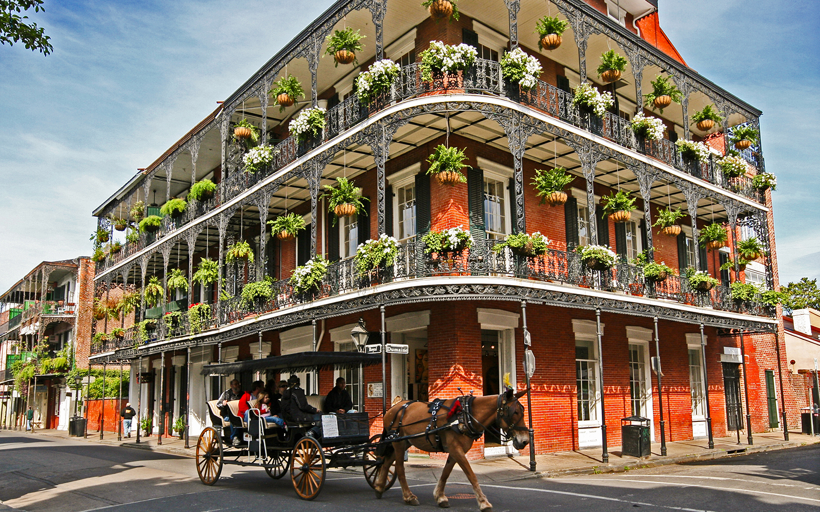 Carriage ride passing historic French Quarter building in New Orleans.