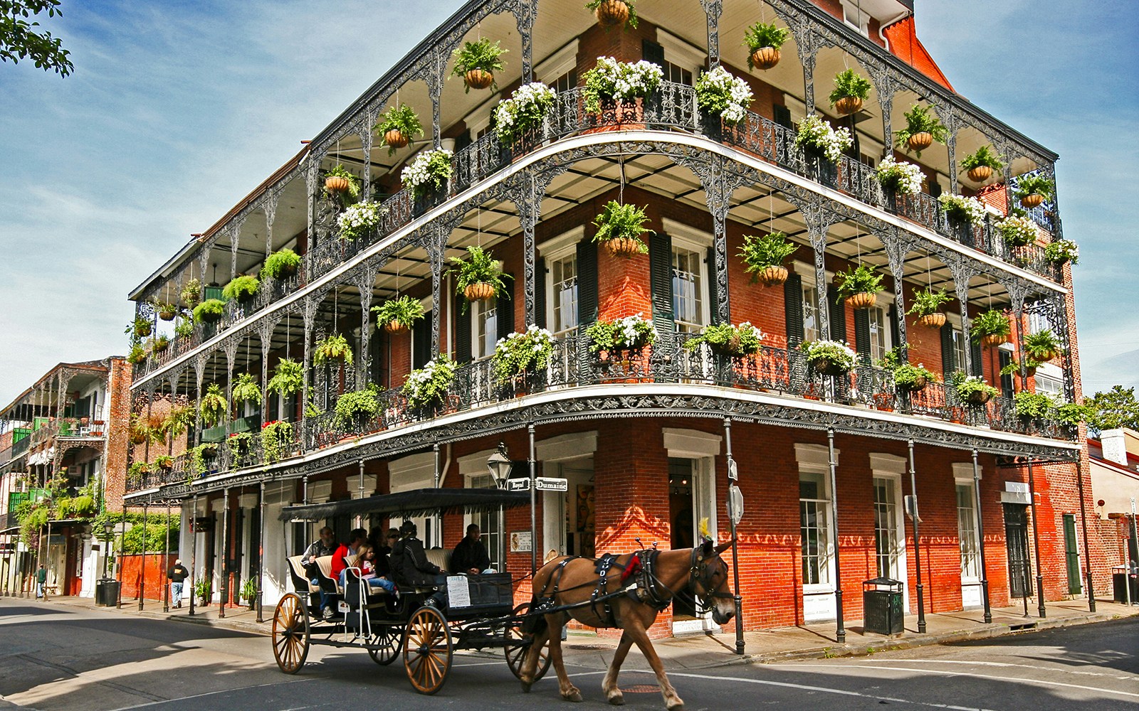 Carriage ride passing historic French Quarter building in New Orleans.
