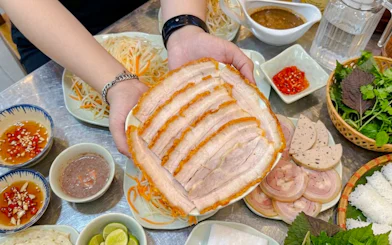 Sliced pork belly with Vietnamese herbs and sauces on Da Nang food tour.