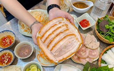 Sliced pork belly with Vietnamese herbs and sauces on Da Nang food tour.