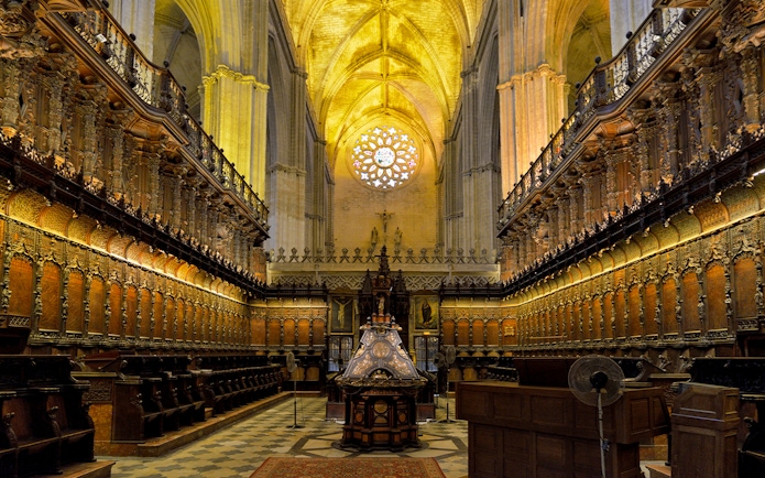 Chapel interior with ornate wooden choir stalls in Cathedral of Sevilla, Spain.