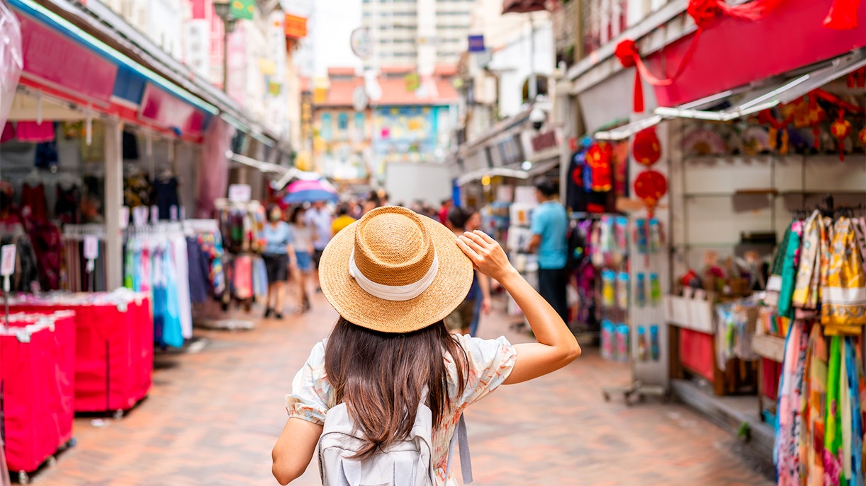 Traveler exploring a vibrant market street in Singapore.