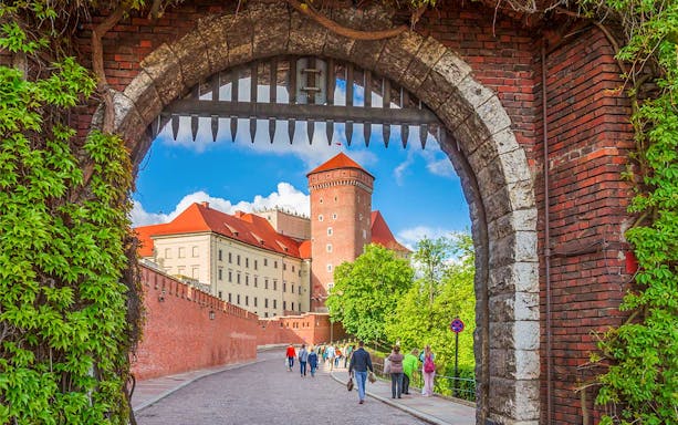 Krakow Old Town walking tour through historic gate with view of Wawel Castle.