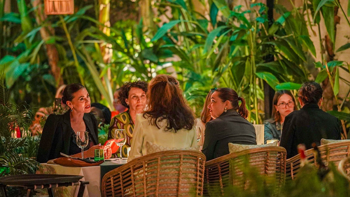 People dining at Nouba Marrakech surrounded by lush greenery.
