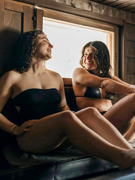 Guests relaxing in a sauna during Northern lights experience in Rovaniemi.