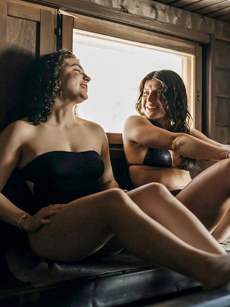 Guests relaxing in a sauna during Northern lights experience in Rovaniemi.