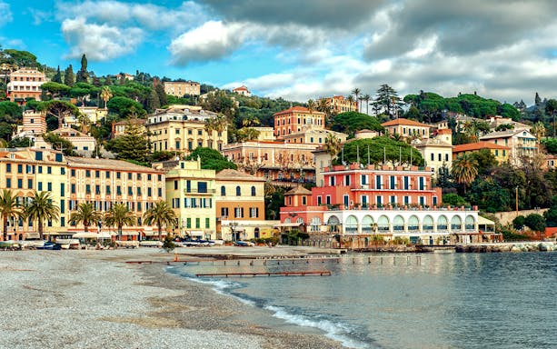 Colorful buildings along the coastline in Portofino, Italy, viewed from the beach.