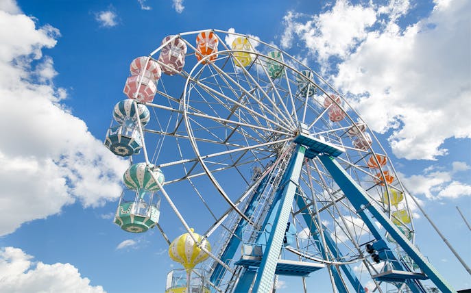 Ferris wheel with colorful gondolas against a blue sky at Old Town, Orlando.