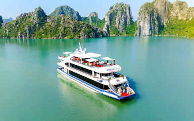 Delux Phong Hai Harmony Cruise sailing in Halong Bay with limestone karsts in the background.