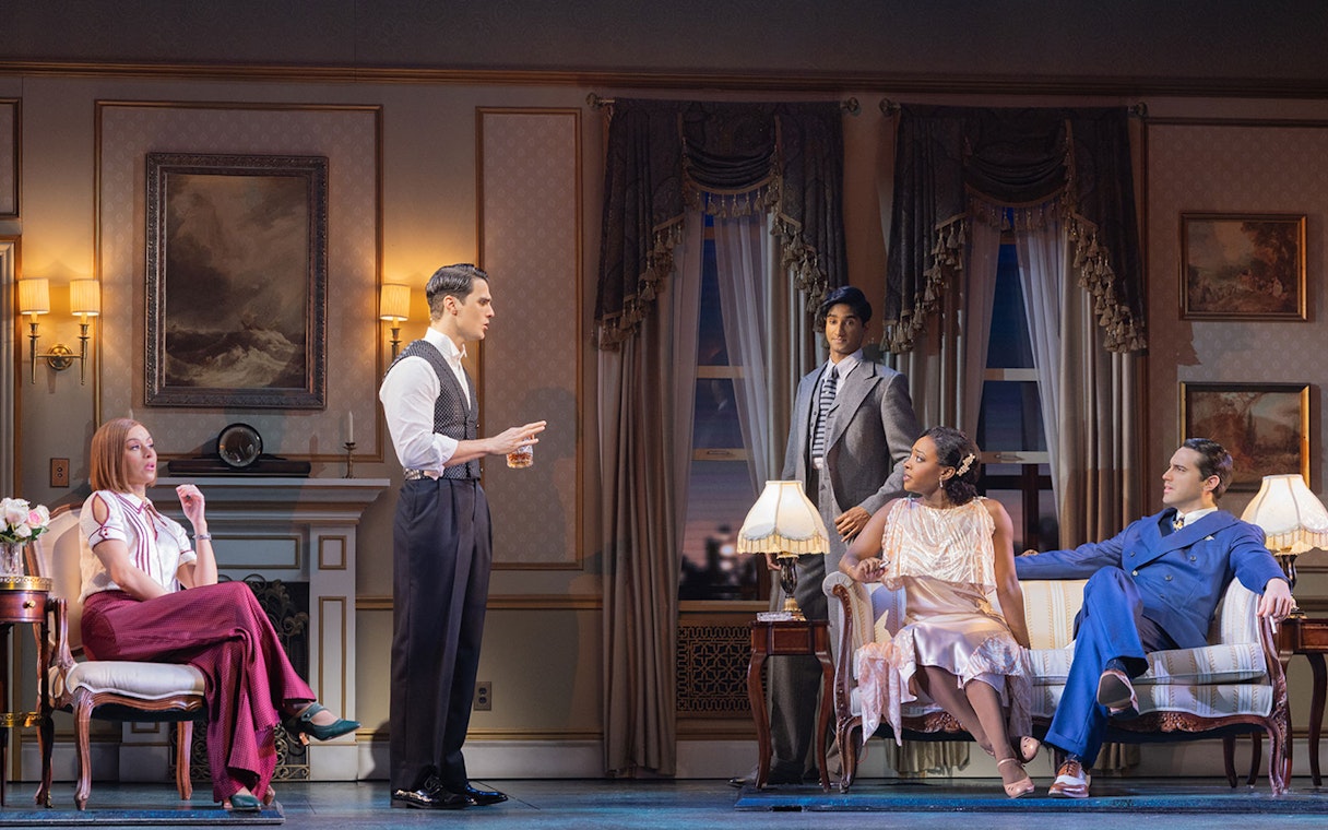Actors performing a scene from The Great Gatsby in an elegant 1920s living room setting.