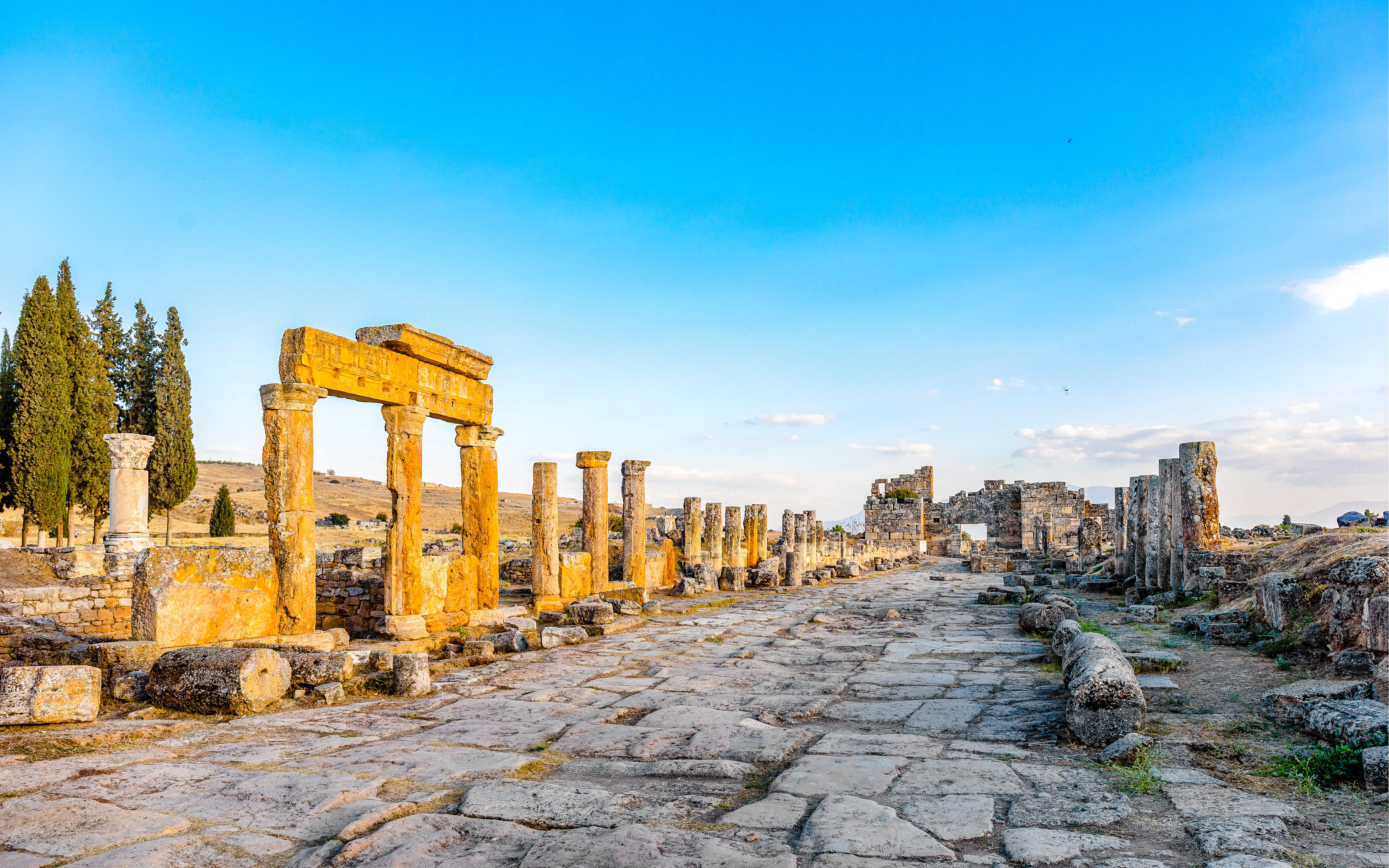 Frontinia Gate and ancient street in Hierapolis, Turkey, with stone columns and ruins.