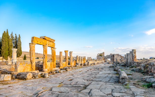 Frontinia Gate and ancient street in Hierapolis, Turkey, with stone columns and ruins.