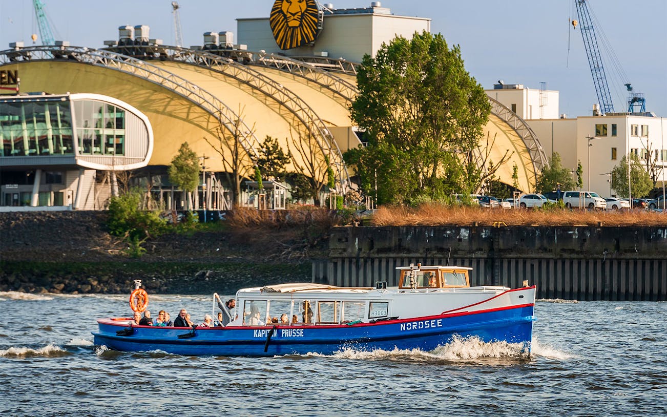 Boat on Hamburg harbor tour passing theater building.