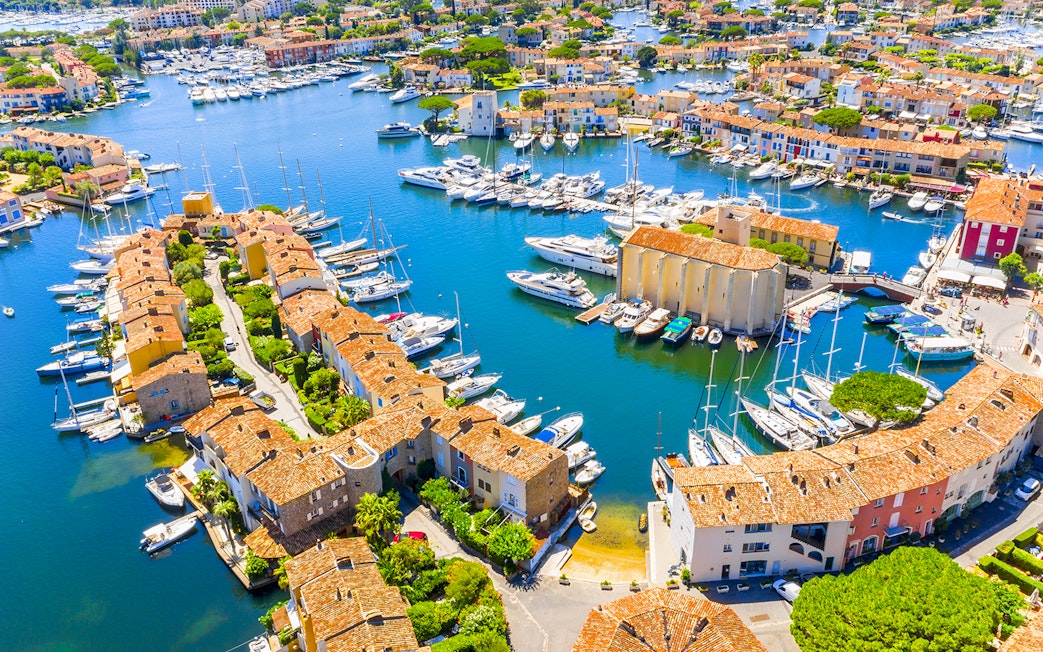 Aerial view of Port Grimaud with boats docked along canals and colorful buildings.