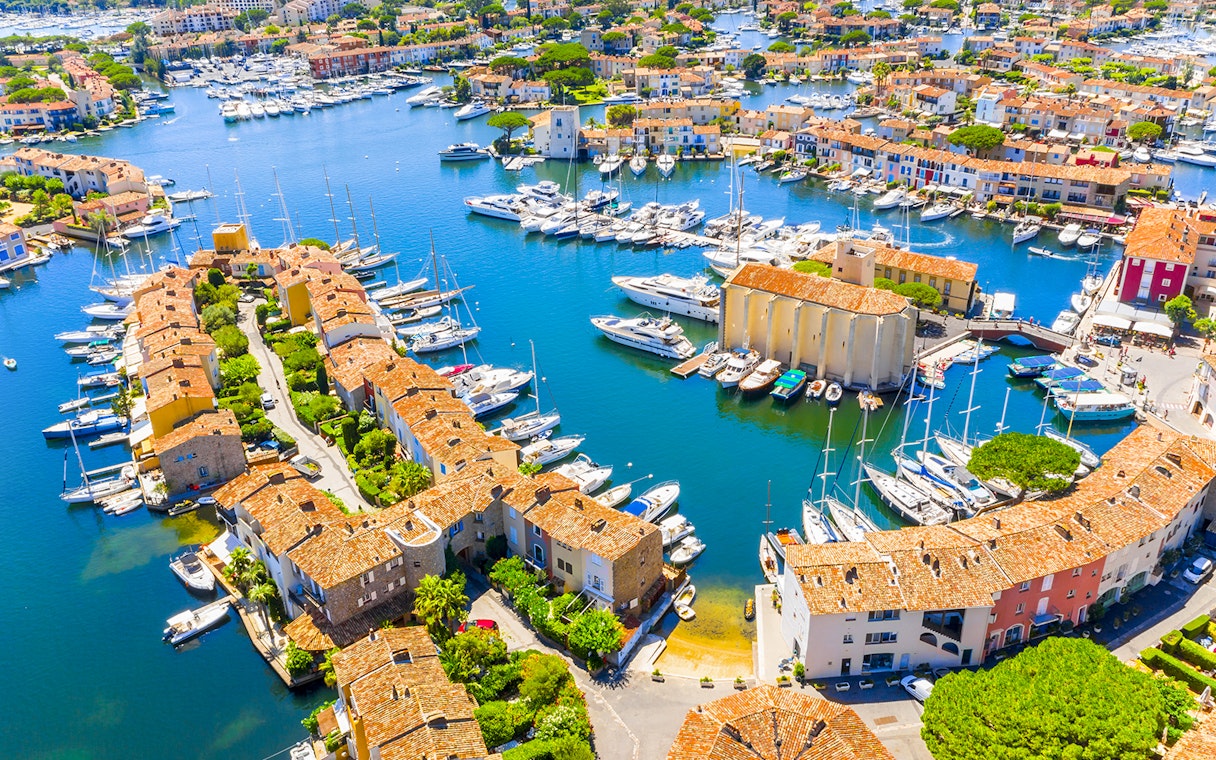 Aerial view of Port Grimaud with boats docked along canals and colorful buildings.