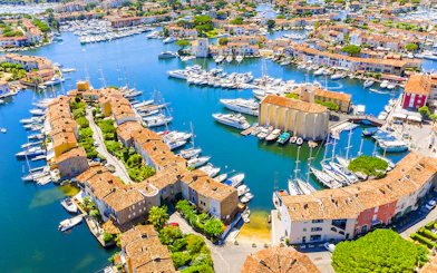 Aerial view of Port Grimaud with boats docked along canals and colorful buildings.