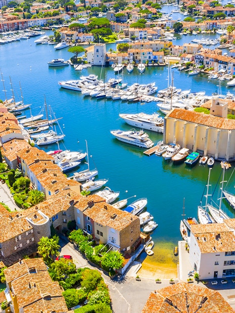 Aerial view of Port Grimaud with boats docked along canals and colorful buildings.