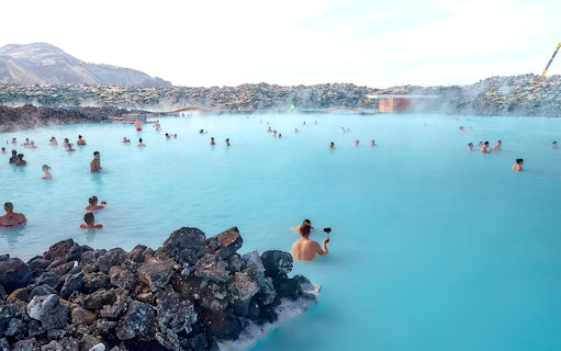 Tourists relaxing in the Blue Lagoon's geothermal waters in Iceland.