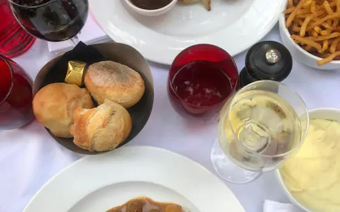 Bread, wine, and French cuisine on a table during Paris Le Marais food tour.