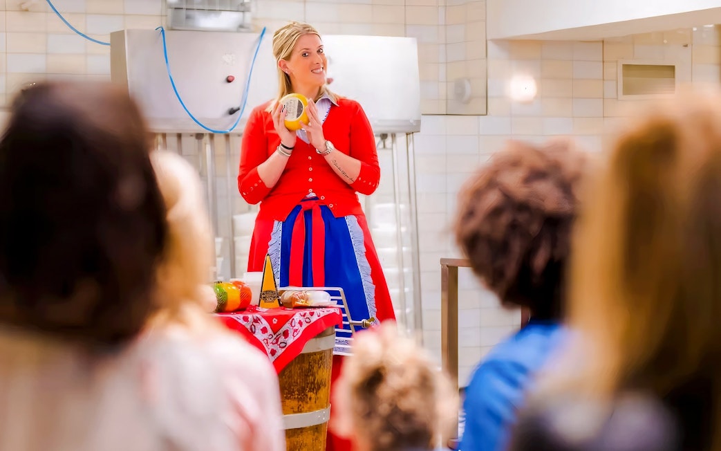 Cheese making demonstration in Edam with a guide holding a cheese wheel.