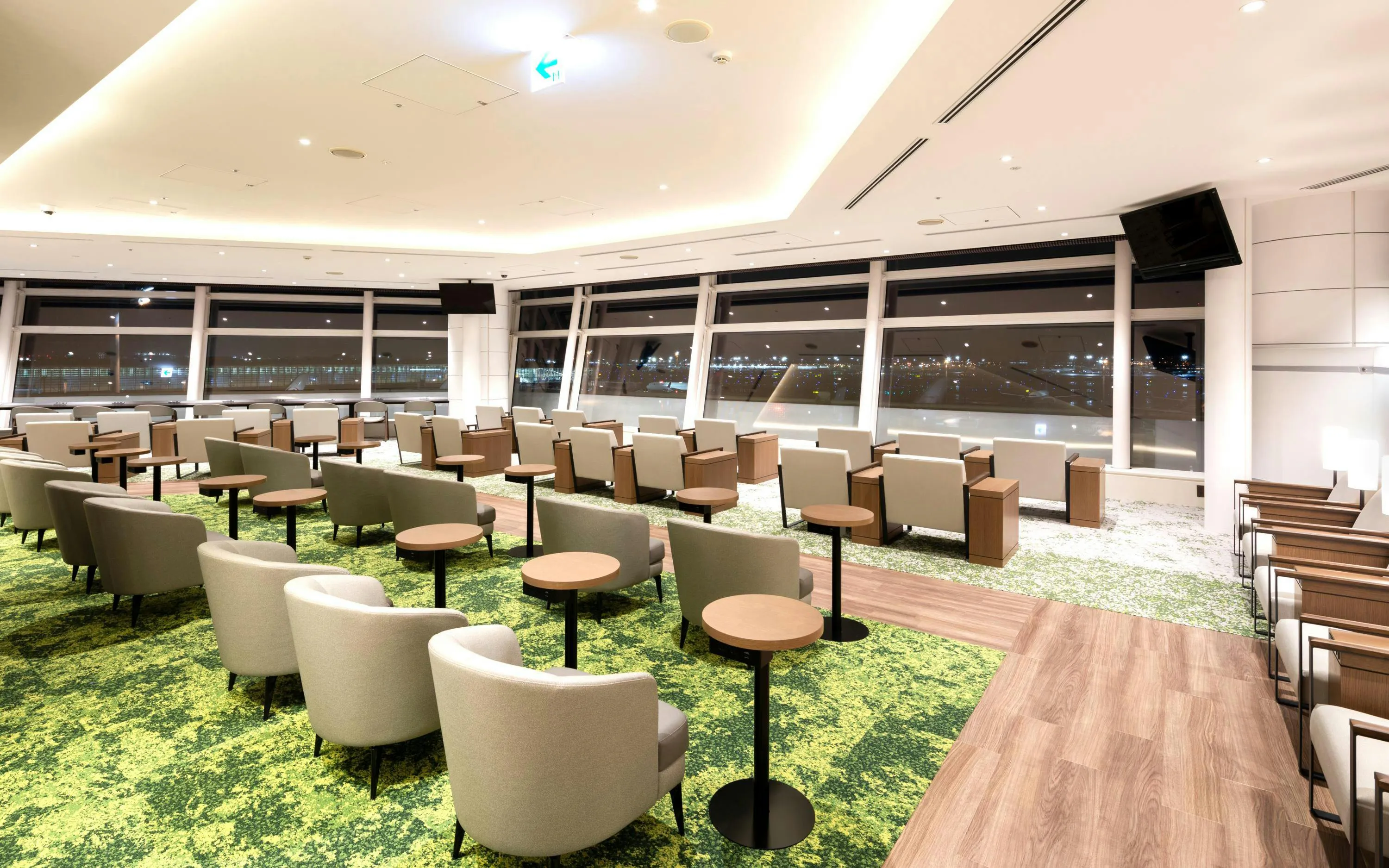 TIAT Lounge seating area with airport runway view at Tokyo International Airport.